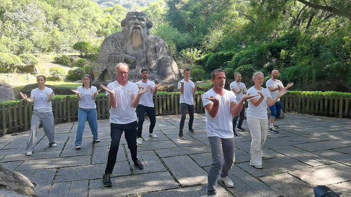 Kampfkunstübung vor einer Statue und Urwald