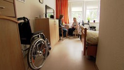 Zwei Frauen sitzen in einem Pflegezimmer