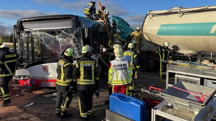 Feuerwehrleute versuchen einen Lkw-Fahrer aus dem Führerhaus zu retten