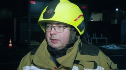 Ein Feuerwehrmann vor einem Feuerwehrauto