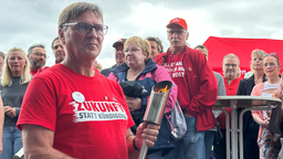 Der Siegerländer Betriebsratsvorsitzende Helmut Renk mit der "Flamme der Solidarität"