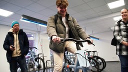 Ein junger Student testet die e-Bike-Ausleihe per Smartphone