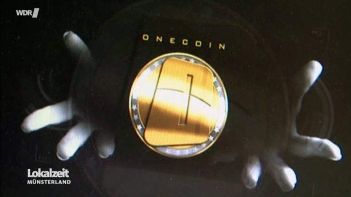 Das OneCoin-Logo zwischen zwei Händen.