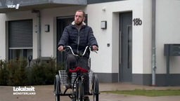 Christian Attemeyer auf einem Rad vor seiner Wohnung.