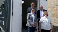 Das Foto zeigt die Verantwortlichen der Tiny Church vor dem Anhänger, in dem sich die Tiny Church befindet