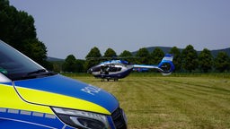 Ein Polizei-Hubschrauber steht auf einer Wiese