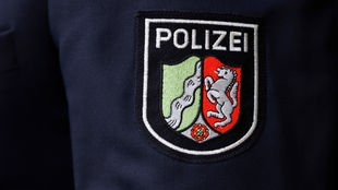 Nahaufnahme des Logos der Polizei NRW auf einem Jackenärmel.