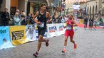 Zwei Läufer des Münster Marathons fordern sich gegenseitig beim Lauf heraus. 