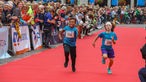 Zwei Jungs liefern sich beim Münster Marathon ein Kopf-an-Kopf-Rennen. 