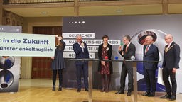 Menschen auf dem Podium bei der Preisverleihung des Nachhaltigkeistpreises im historischen Rathaus Münster