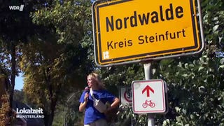 Louisa Melzow steht neben dem Ortsschild von Nordwalde.