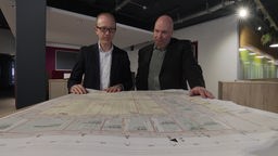 Thomas Paar und Thomas Sting mit einem Plan der unterirdischen Datenautobahn