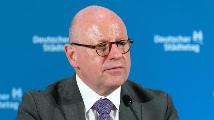 Münsters Oberbürgermeister Markus Lewe vor blauer Werbewand