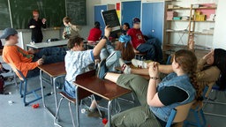 Chaos im Klassenzimmer, hilflose Lehrerin - Symbolbild