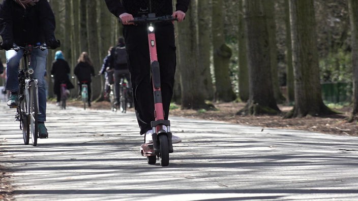 Eine Person auf einem E-Scooter fährt auf der Promenade in Münster.