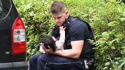 Ein Polizist tröstet ein Kleinkind nach dem Messerangriff in Dorsten.