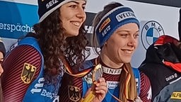 Die Winterbergerin Cheyenne Rosenthal und Doppelpartnerin Jessica Degenhardt aus Altenberg halten ihre Medaillen