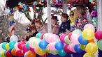 Kinder in Kostümen stehen auf einem bunt dekorierten Wagen auf dem Karnevalsumzug in Münster.