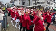 Eine Fußgruppe mit weiblichen Karnevalistinnen in roten Kostümen auf dem Rosenmontagszug in Bocholt.