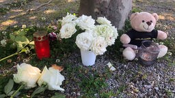 Blumen wurden zusammen mit Kerzen und einem Teddybär am Tatort niedergelegt