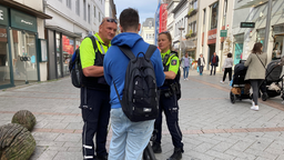 Polizisten kontrollieren einen E-Scooter-Fahrer in der Iserlohner Innenstadt