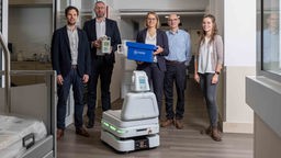 Gruppe vor Service-Roboter im Franziskus Hospital Münster