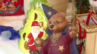 Nahaufnahme eines als Zauberer verkleideten Teddybären, der neben weihnachtlichen Figuren in einem Sozialkaufhaus steht