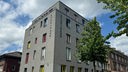 Ein großes graues freistehendes Wohnheim mit horizontaler Aufschrift: Studentenwohnheim