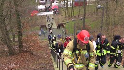 Teilnehmer der Feuerwehr steigen die Treppen hinauf