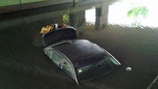 das Auto steht im Wasser unter der Brücke