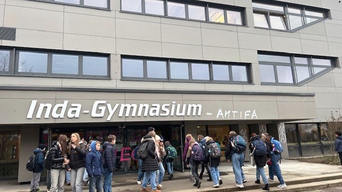 Aachener Gymnasium mit Schülern davor. Neben der Schulaufschrift:Inda-Gymnasium steht mit Graffiti Antifa geschrieben.