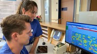 Zwei Angestellte des Klinikums schauen auf einen Monitor