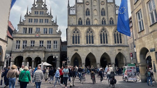Rathaus in Münster mit Menschen auf der Straße davor