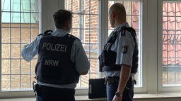 Zwei Polizeibeamte am Fenster im Rathaus