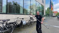 Ein Mann putzt die Fenster der Bezirksregierung Münster.