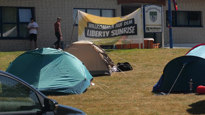 Zelte auf einem Campingplatz, wo vor einigen Wochen ein politisches Camp mit einem Waffenworkshop stattfand. Im Hintergrund ein Schild mit der Aufschrift: "Willkommen auf dem Liberty Sunrise"