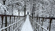 Hängebrücke mit Schnee bedeckt