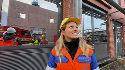 Mitarbeiterin schaut hoch zu Wasserstoffspeicher 