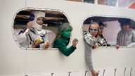 Verkleidete Kinder in einem gebastelten Raumschiff.
