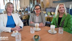 Katrin Rodeheger, Andrea Geiger und Barbara Köß sitzen an einem Tisch und trinken Kaffee. 