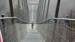 Feuerwehrmann läuft über Hängebrücke 