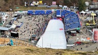 Das Ende einer Skischanze, umgeben von Tribünen.