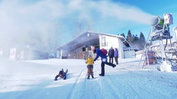 spielende Kinder und Eltern auf der Piste