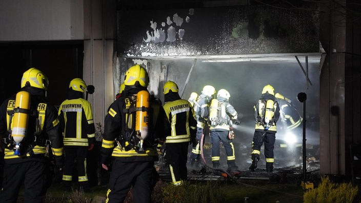 Feuerwehrleute bei Löscharbeiten an der ausgebrannten Wohnung.