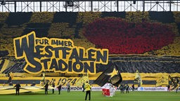  BVB-Fans im Fanblock zeigen riesiges Plakat mit der Ausschrift "Für immer Westfalenstadion" 