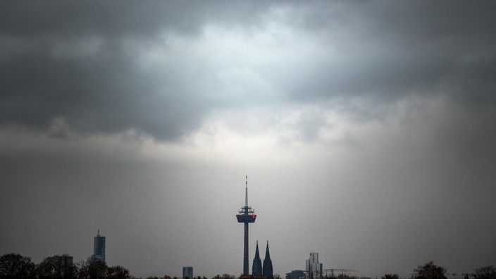 Graue Wolken ziehen über den Kölner Dom und den Fernsehturm