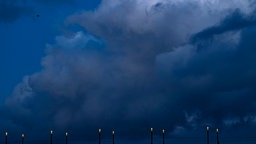 Wolken türmen sich über den Laternen auf der Kennedybrücke.