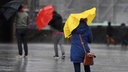 Fußgänger kämpfen gegen Regen und Wind