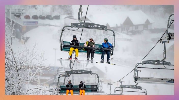 Skifahrende sitzen in einem Sessellift