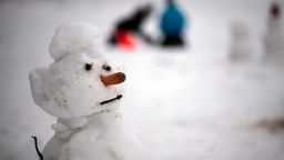 Ein Schneemann steht im Skigebiet Weißer Stein.